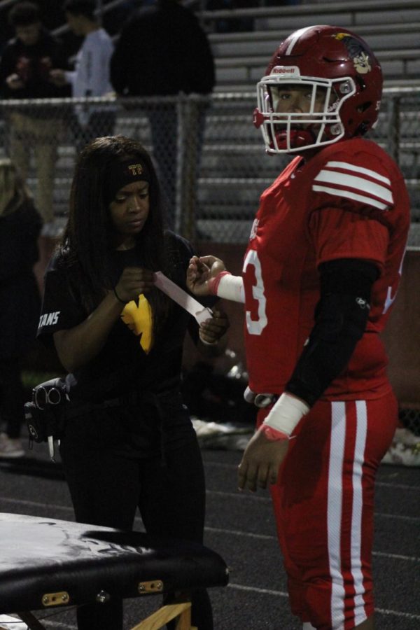 Taping up a football player is all part of the job to ensure that athletes stay safe in competition.