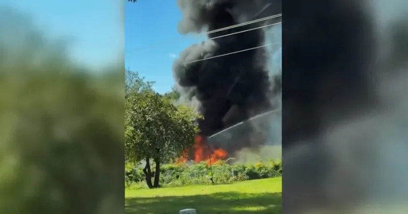 Military F-16 fighter jet crash scene with flames after impact in Michigan